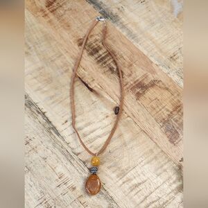 Tan leather necklace with earthy amber colored stone pendant.